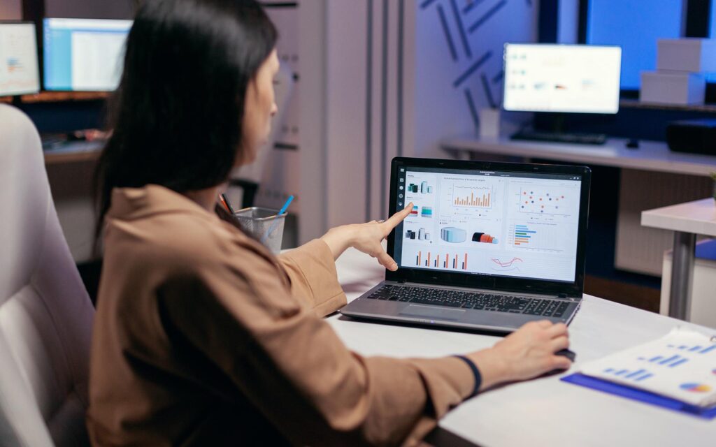 Busy employee pointing at graph working to finish a deadline